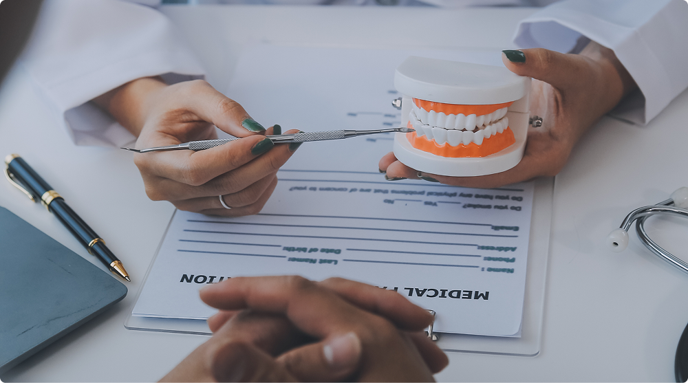 Dentist hands with dental explorer and tooth model over a medical history form at Westlake Smile Design